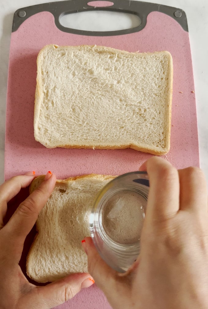Indents being made in bread with a drinking glass.