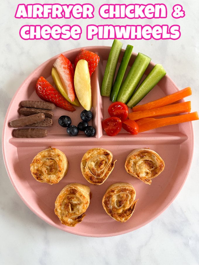 Air Fryer Chicken & Cheese Pinwheels served on a divided plate with chopped fruit and vegetables