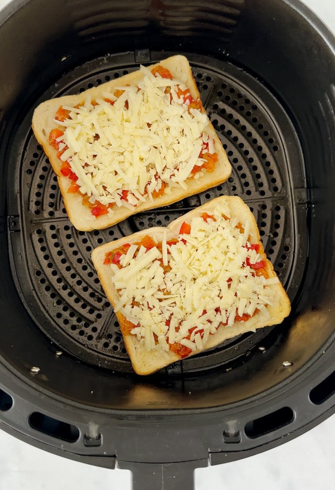 Pizza toast loaded into the air fryer ready to be cooked.