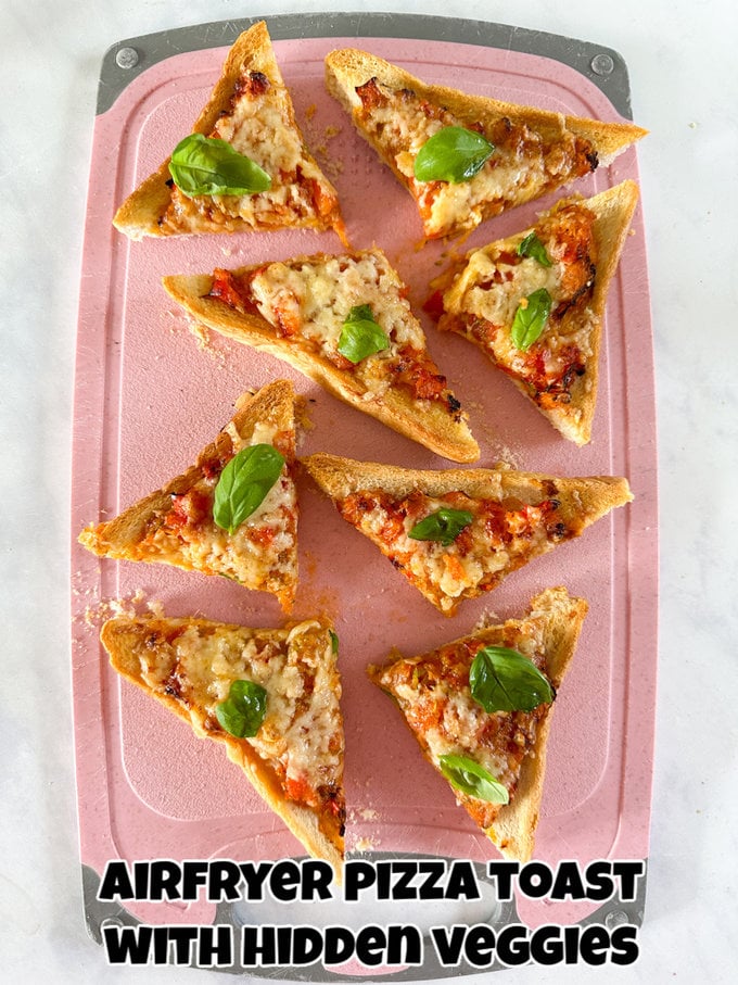 Airfryer Pizza toast cut into triangles and served on a pink chopping board garnished with small basil leaves