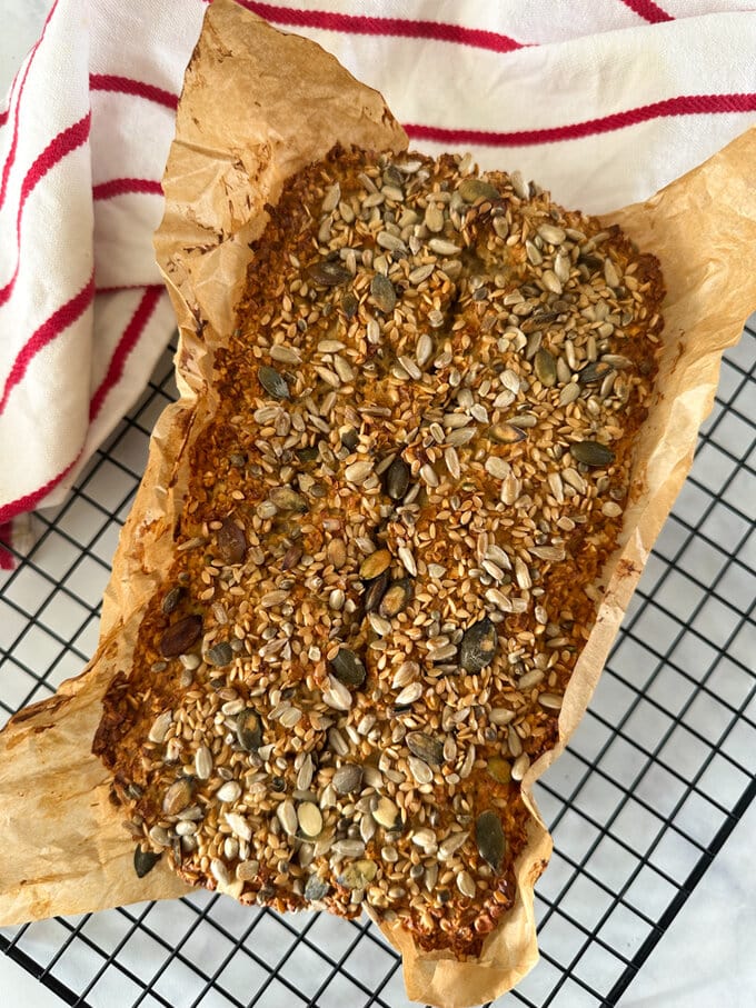 a loaf of freshly baked porridge bread cooling on a wire rack