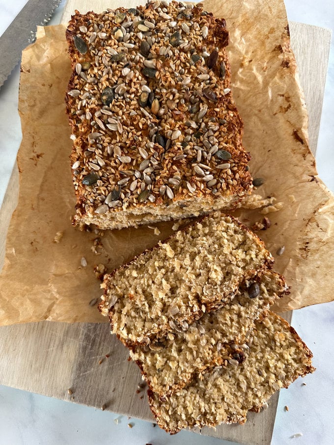 the freshly baked porridge bread sliced on a wooden chopping baord