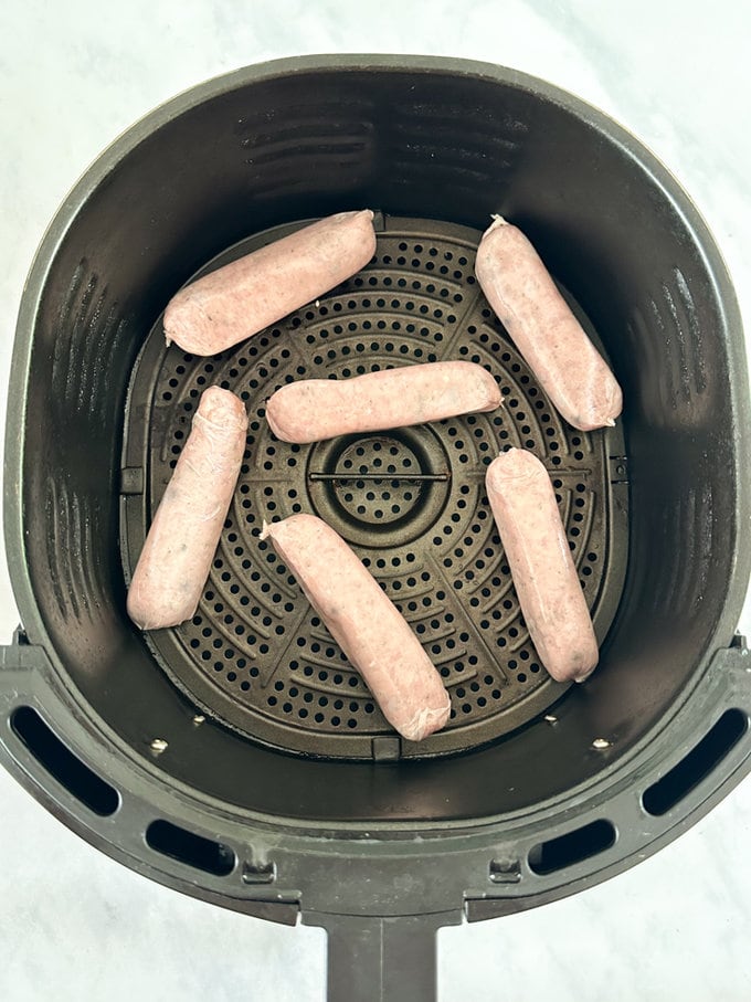 Raw sausages placed into the Airfryer drawer.