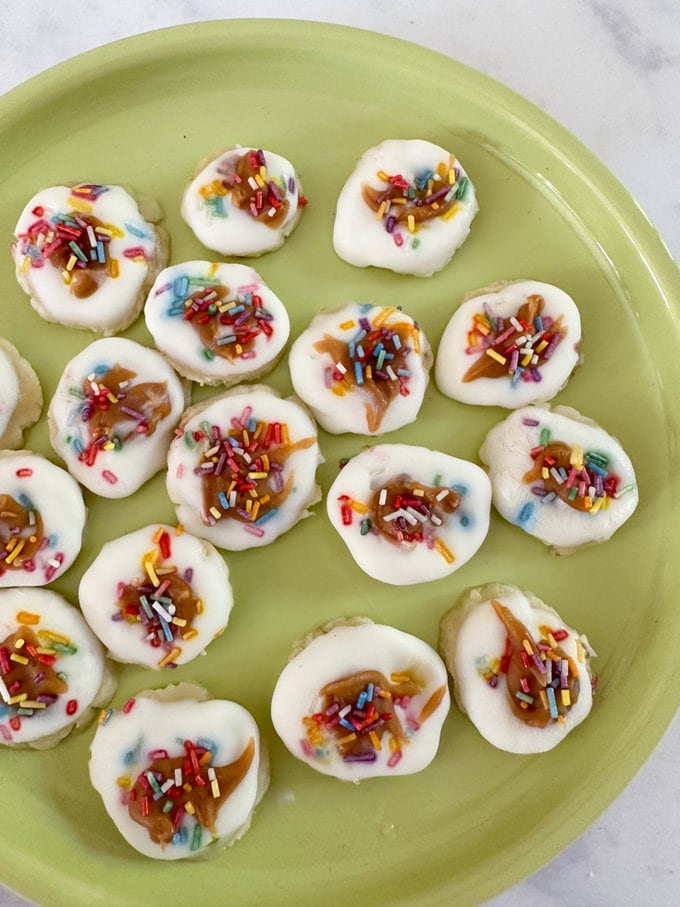 Finished smashed banana & yogurt bites presented on a green plate, ready to be eaten.