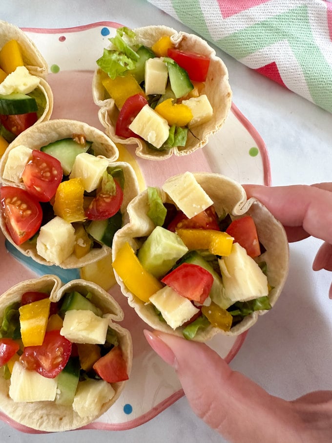 Filled salad cups presented on a colorful plate.