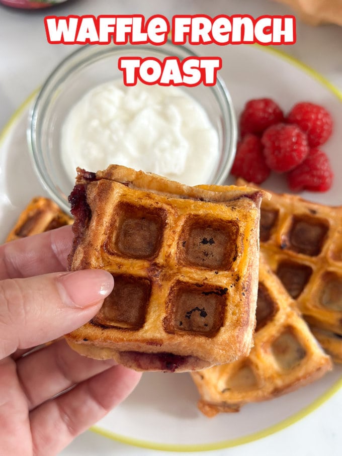 Waffle French Toast on a white plate with a small serving of fresh raspberries and a small ramekin of greek yogurt.