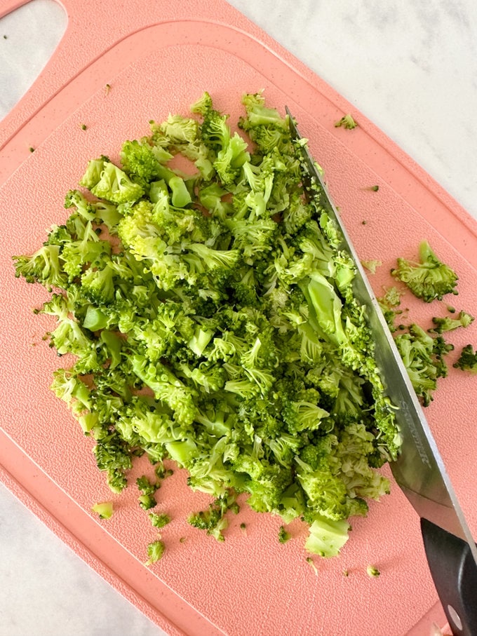 Broccoli being chopped into very small pieces.