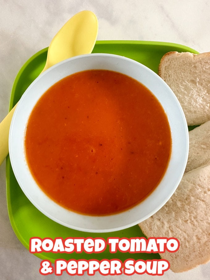 Kid-Friendly Soup Recipes - Roasted Tomato & Red Pepper soup in a white bowl with a side serving of bread
