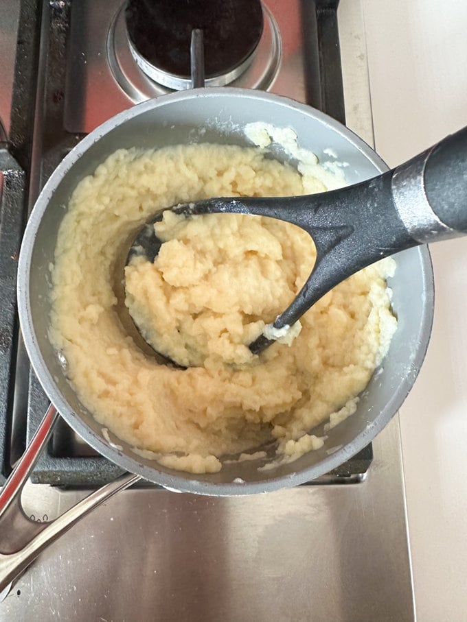 Potatoes being mashed up.