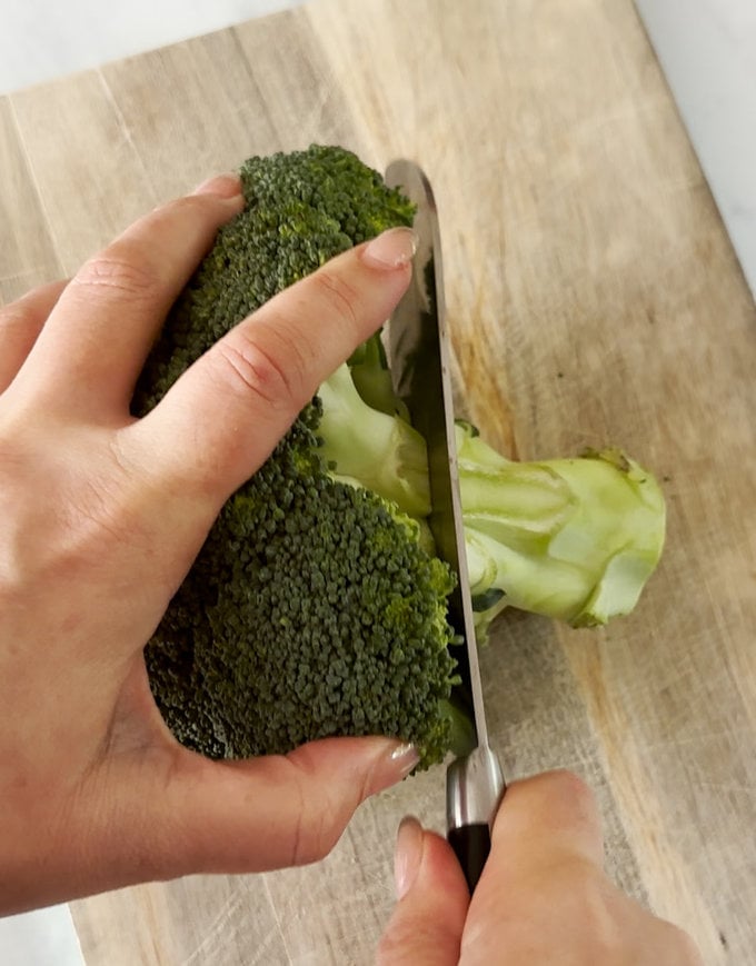 Stalk being chopped of the broccoli head.