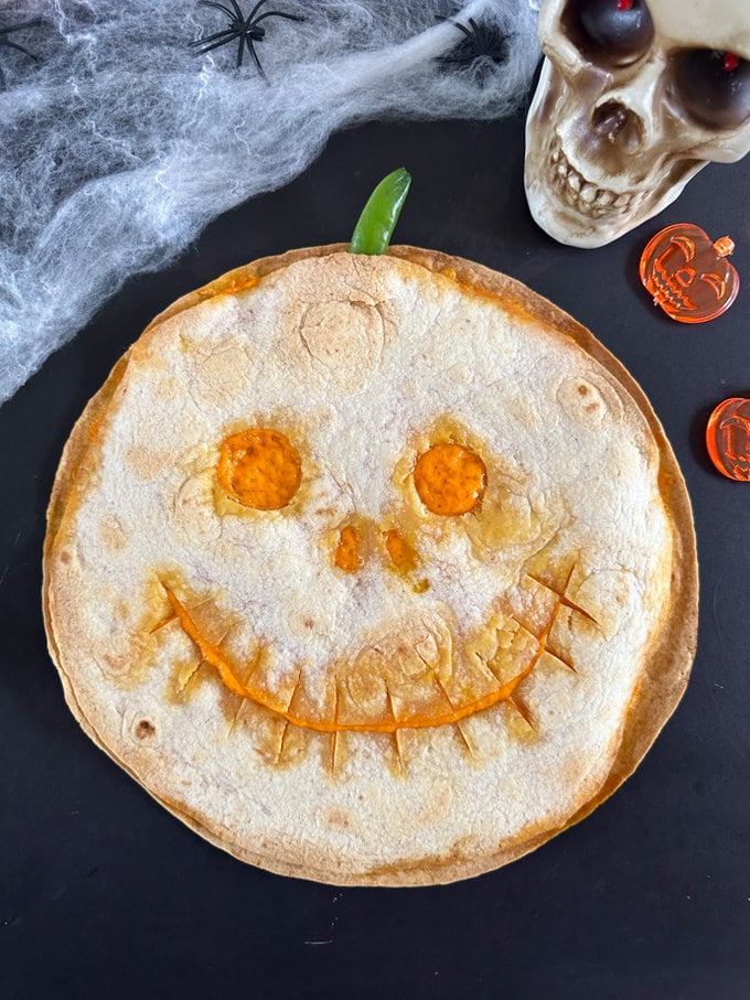 Jack O' Lantern quesadilla served on a scary Halloween back ground.