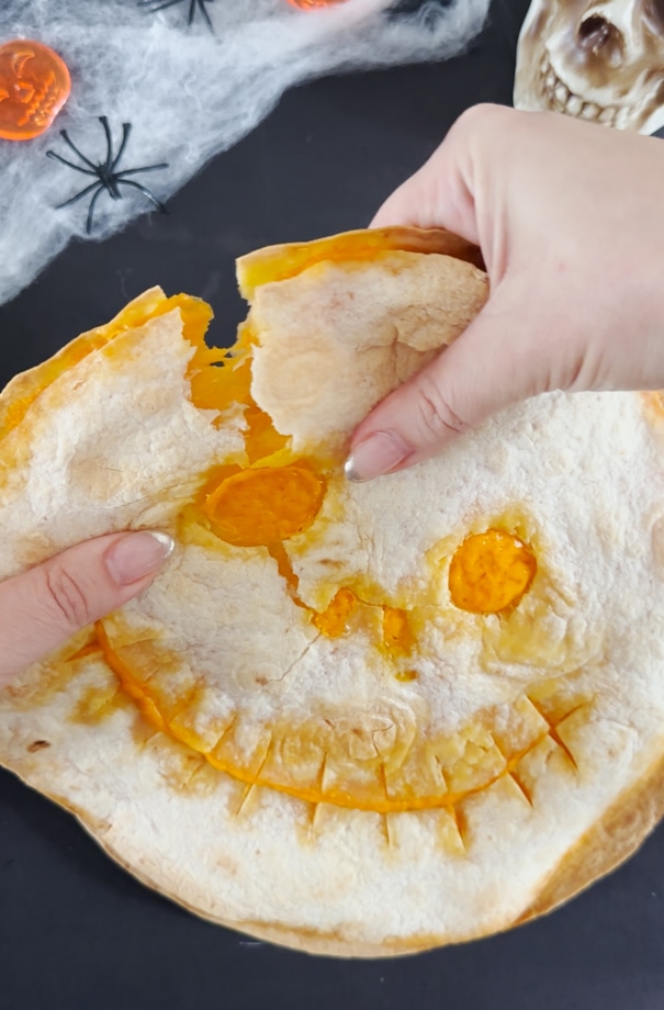 Quesadilla being torn apart ready for sharing with friends and family.