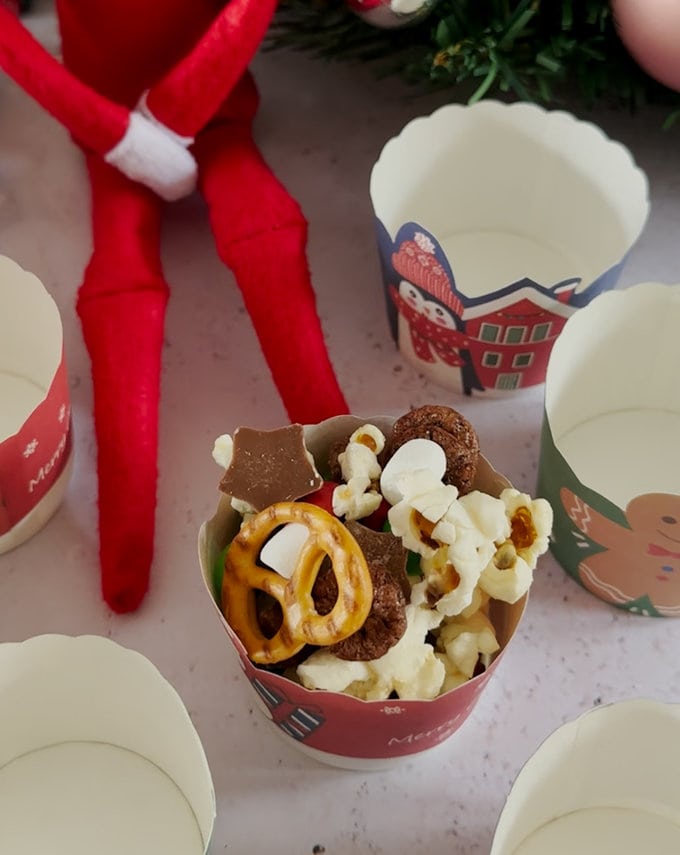 Trail mix being added to the muffin cases.