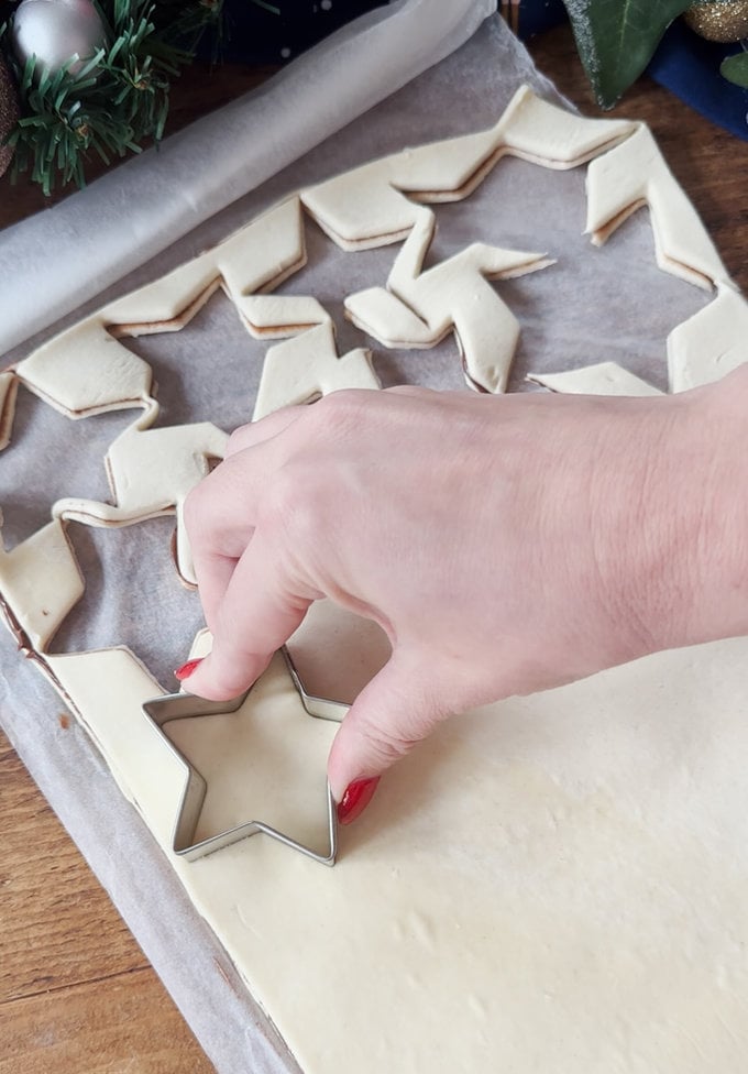 Star shapes being cut out of the pastry with a cookie cutter.