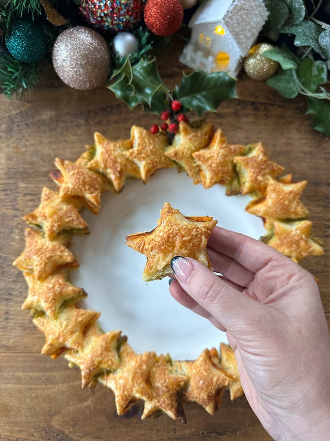 Star shaped puff pastry with red and green pesto,served on a round white plate. One of stars is close to the camera to show you a close up.