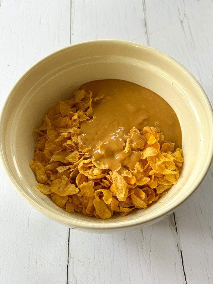 Melted butter and oil added to a bowl of cornflakes.