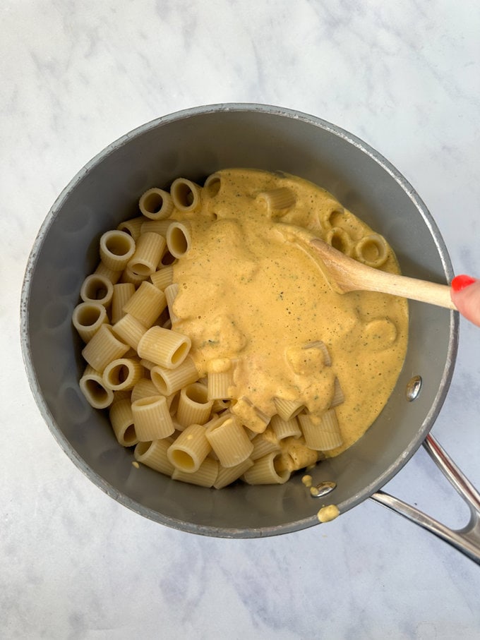 Blitzed veggies added to cooked pasta in saucepan.