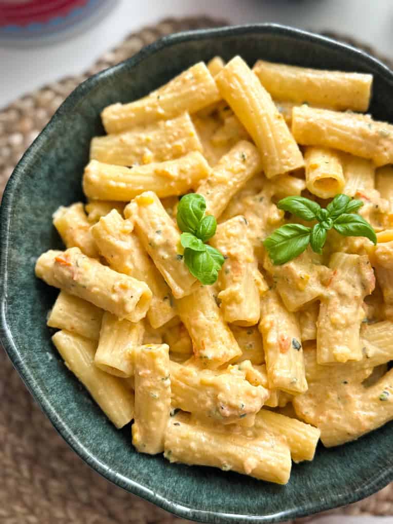 Airfryer Creamy hidden veg pasta sauce served over tube pasta shaped and garnished with a sprig of basil.