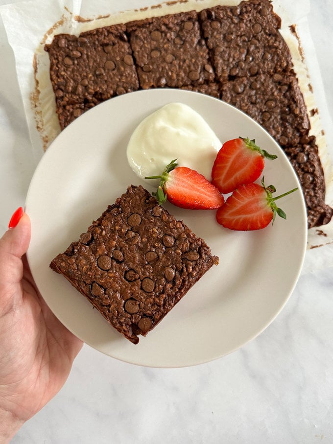 Chocolate Brownie Oat Breakfast Bars served with a dollop of yogurt and fresh yogurt.