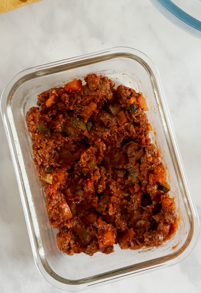 Leftover Bolognese sauce in a glass container.