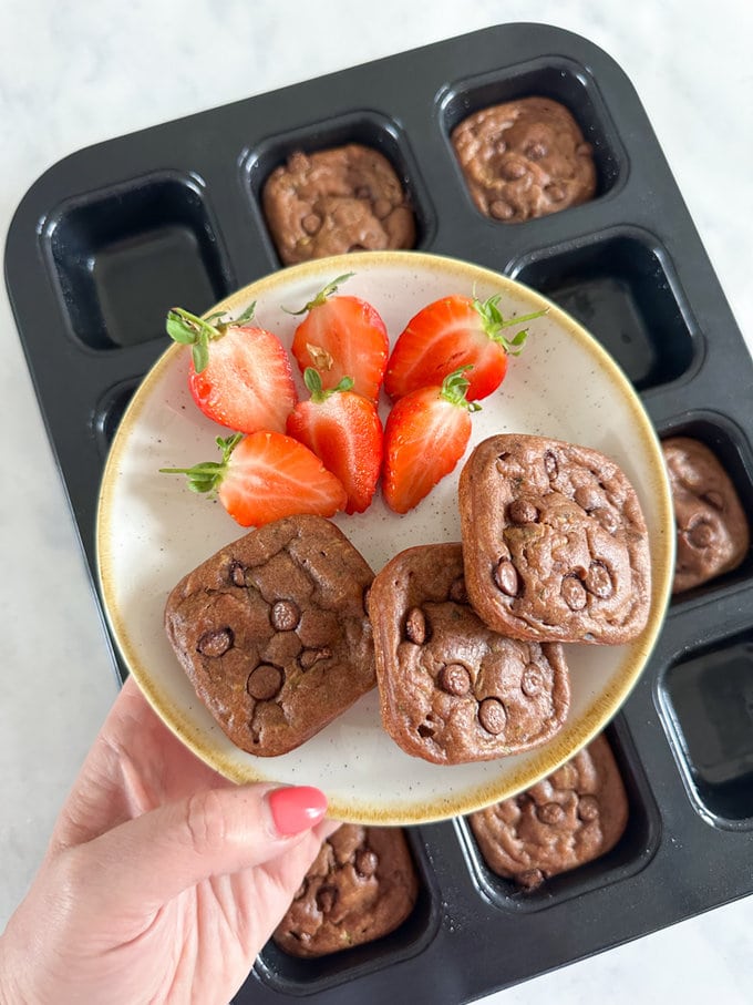 Mini Chocolate Banana Breads served on a plate and garnished with fresh strawberries.