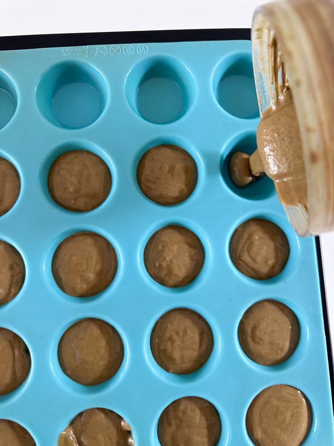 Muffin mixture being added to the muffin tray.