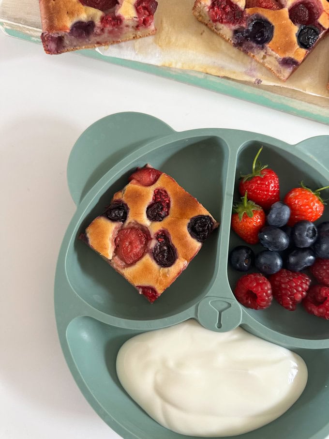 A small square shaped piece of breakfast cake served on a child's divided plate.
