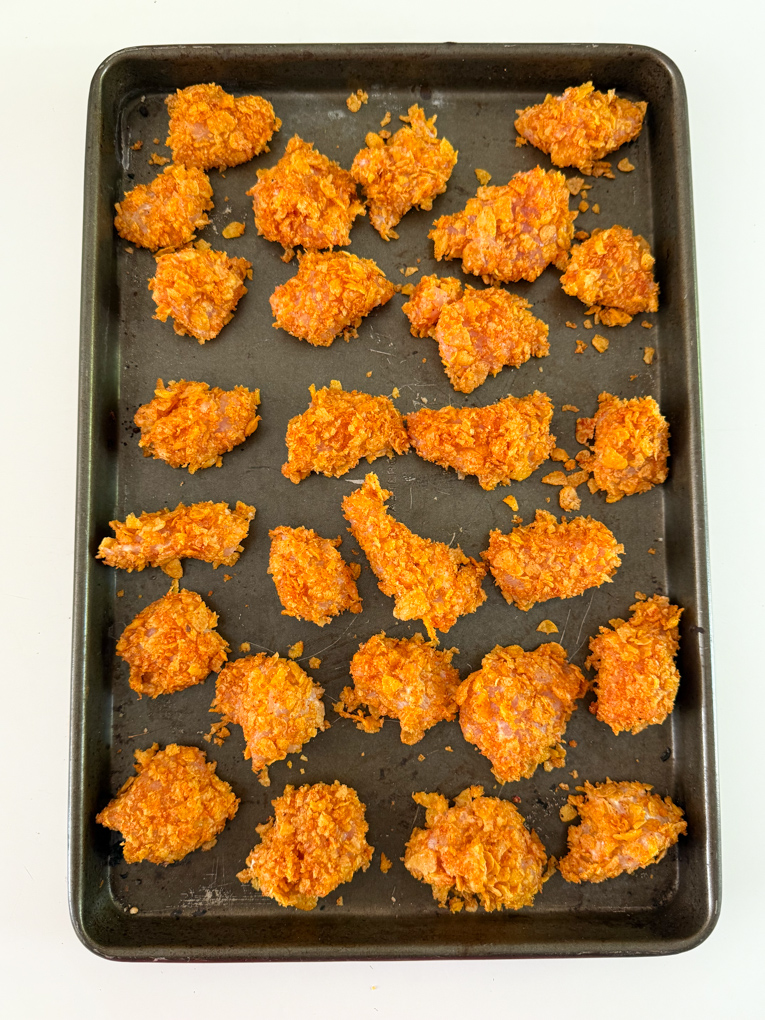 Cripsy Cornflake Nuggets arranged on a baking tray.