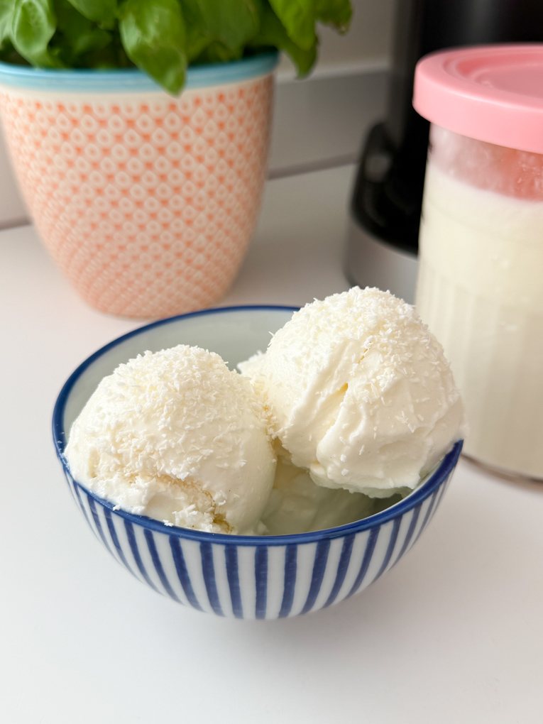 Two scoops of Ninja Creami Coconut Frozen Yogurt in a blue and white striped ice cream bowl.