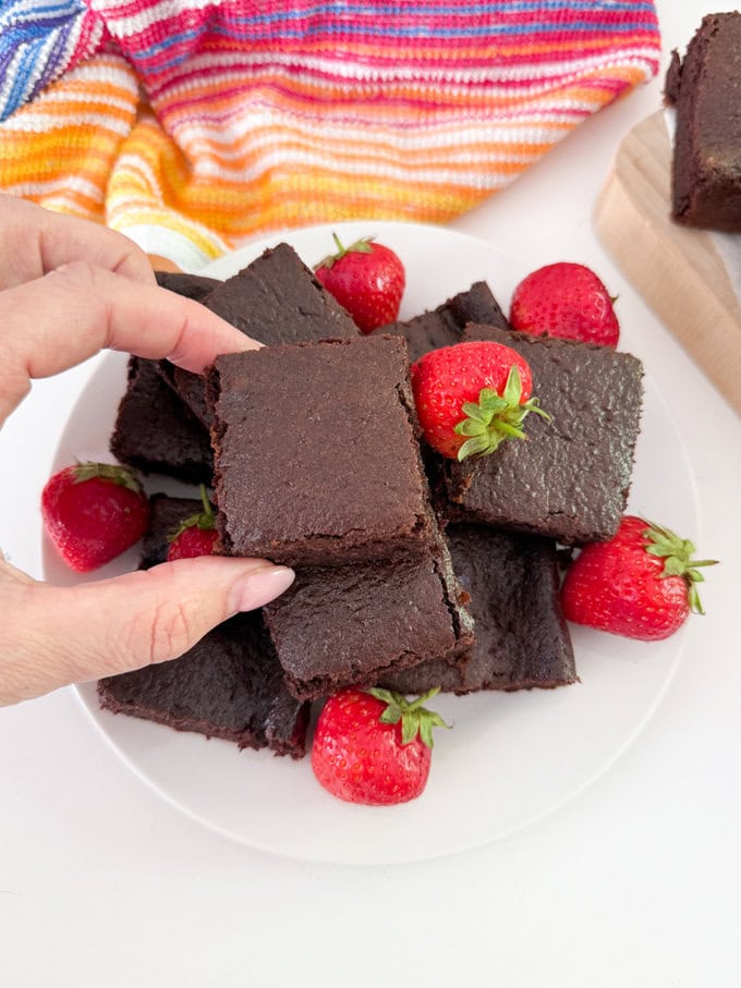 A big stack of Chocolate cake bars served with whole strawberries.