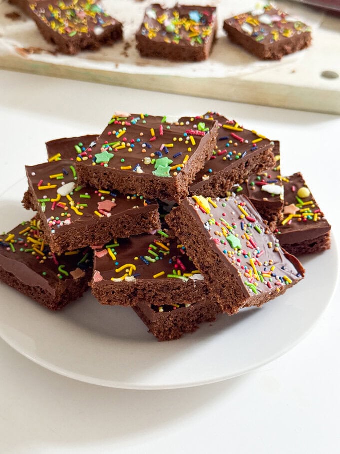 A big pile Chocolate Weetabix Bars cut into small squares and decorated with brightly coloured sugar strands.
