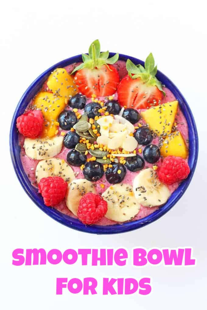 A blue bowl containing a pink smoothie, freshly chopped fruits and a sprinkling of granola on top.