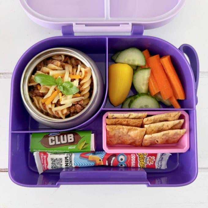Leftover Spaghetti Bolognese served in a bright purple hot & cold lunch box, served with chopped,fresh veggies.