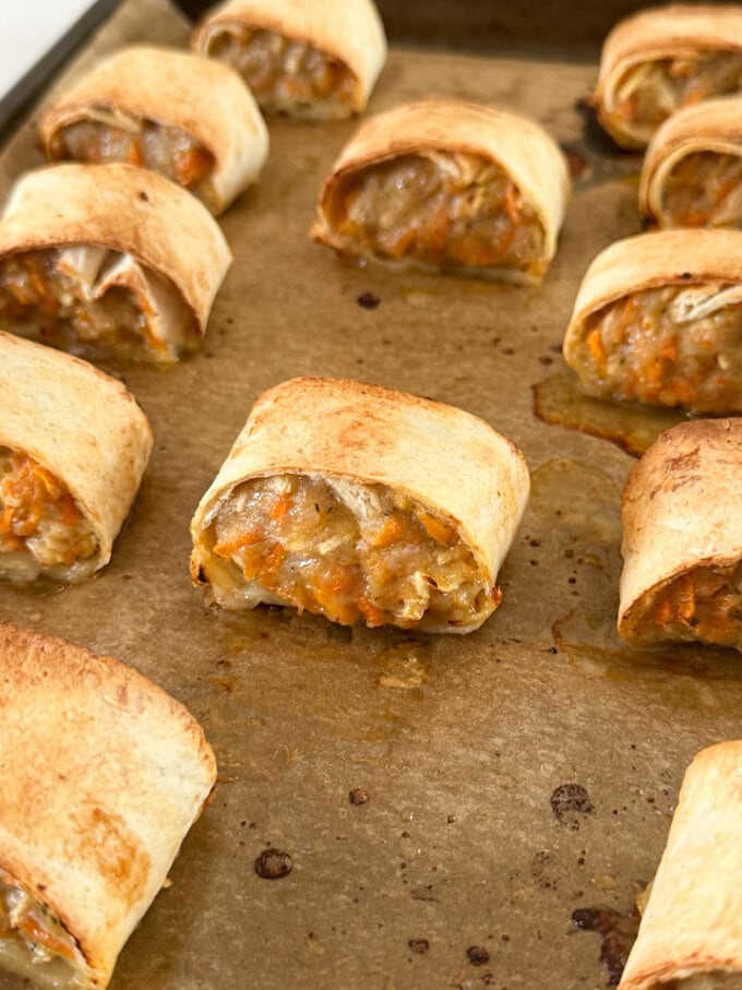 Apple & Carrot Sausage rolls on a baking tray, fresh out of the oven.