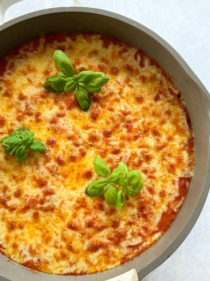 One Pot Hidden Veg Gnocchi served in a oven proof dish and garnished with sprigs of basil.