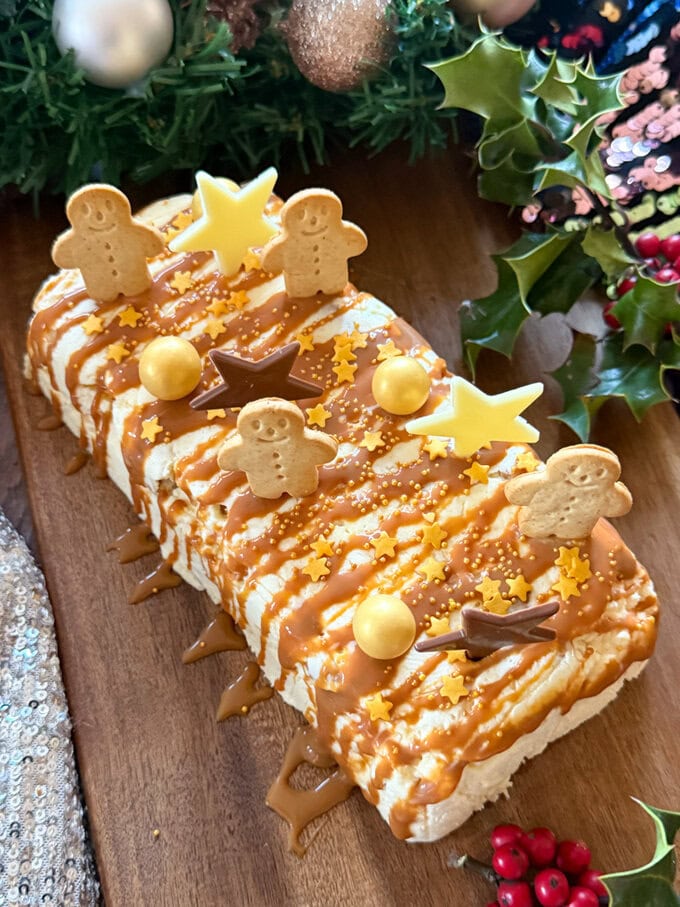 White Chocolate Semifreddo decorated with white chocolate stars,mini gingerbread men biscuits an drizzled with caramel sauce. Surrounded by festive decor.