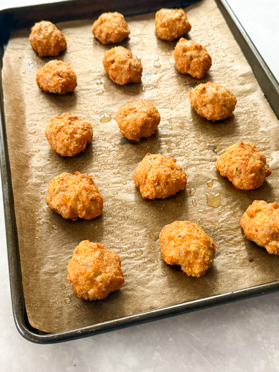 Chicken nuggets arranged on a baking tray fresh out of the oven.