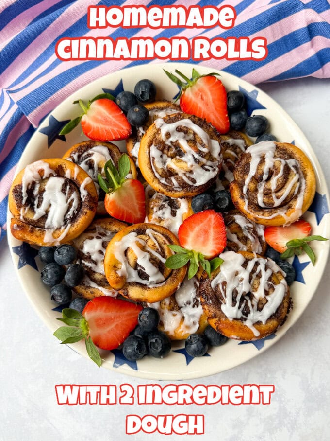 Cinnamon Rolls arranged on  a large round plate and beautifully garnished with chopped strawberries and blueberries. 
