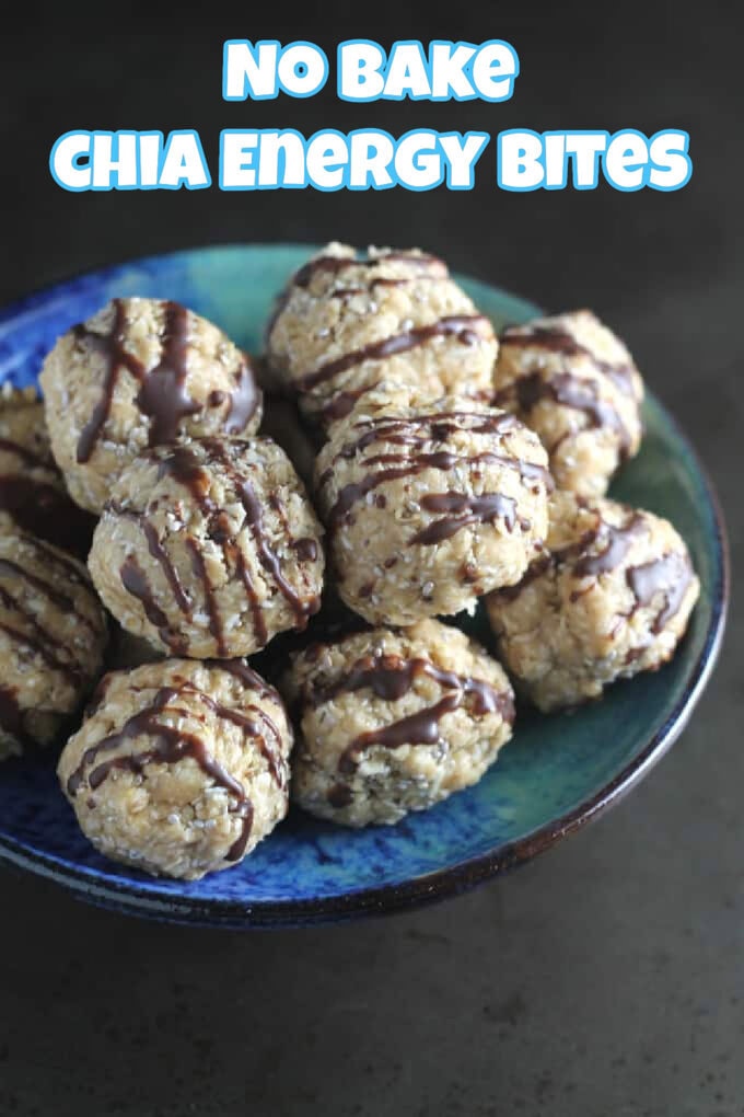 A blue bowl containing a batch of no bake chia energy bites drizzled with milk chocolate.