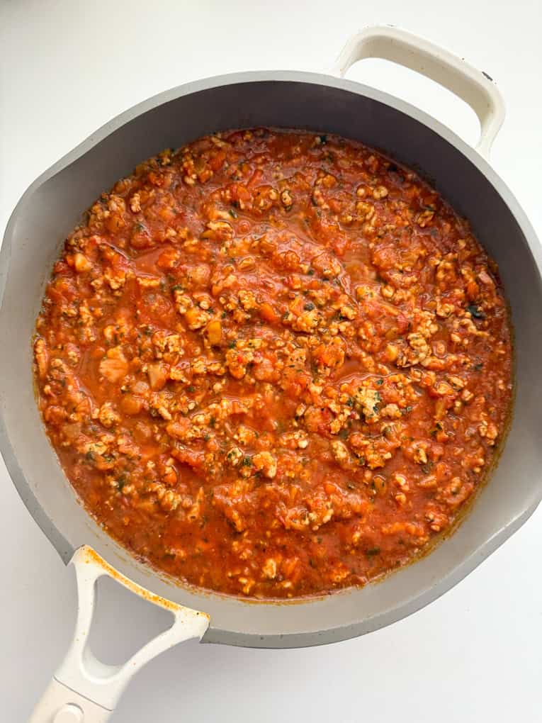 Chicken mince bolognese cooking in a saucepan.