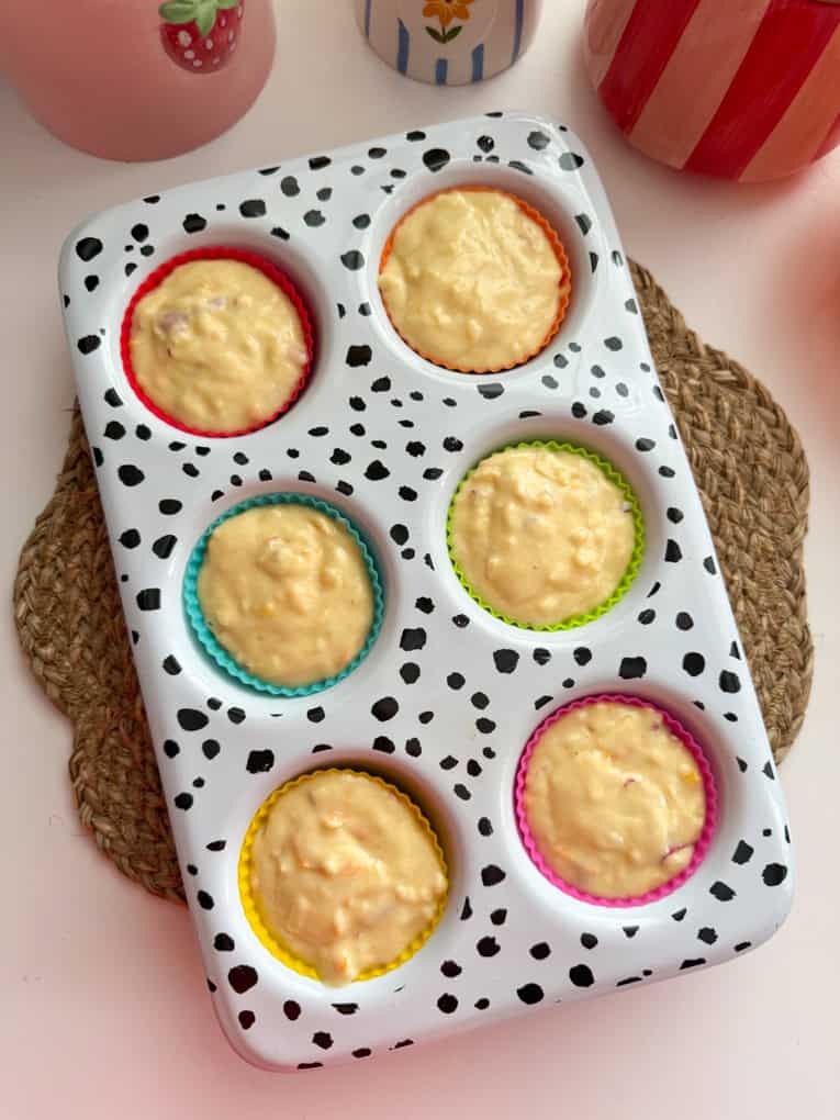 Impasto per muffin alle mele e arancia in uno stampo per muffin con stampa dalmata pronto per essere infornato.
