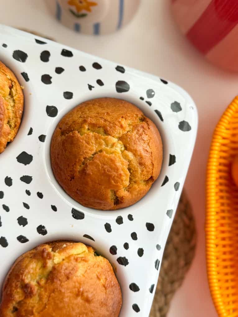 I muffin alle mele e all'arancia vengono serviti in una teglia per muffin con stampa dalmata.