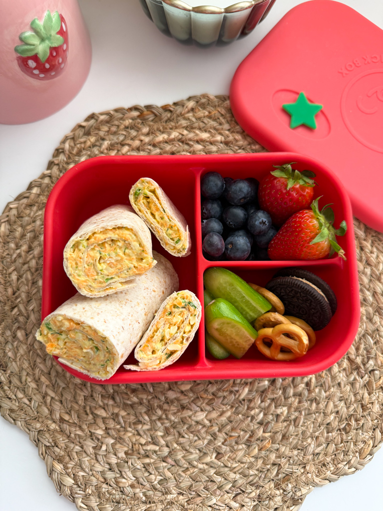 Veggie Cheese wraps served in a bright red child's lunchbox along with other lunchtime treats.