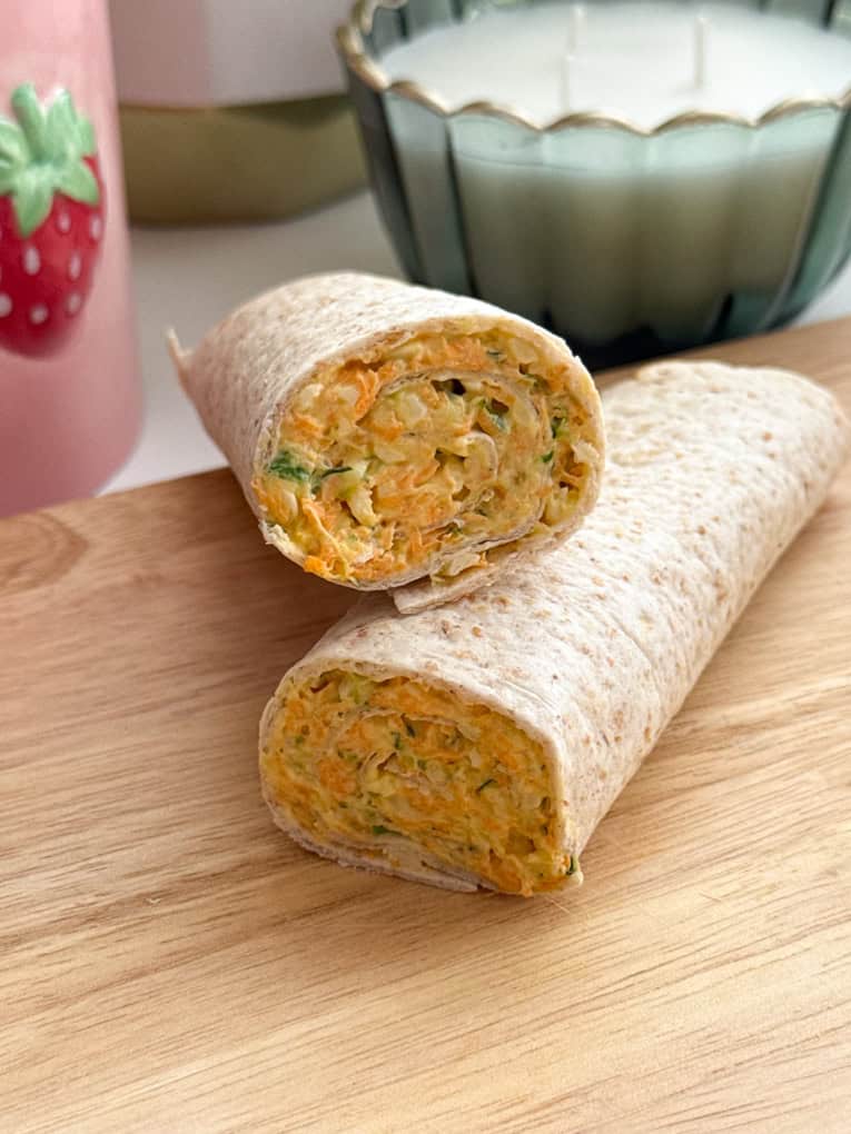 Veggie cheese wraps on a wooden chopping board.