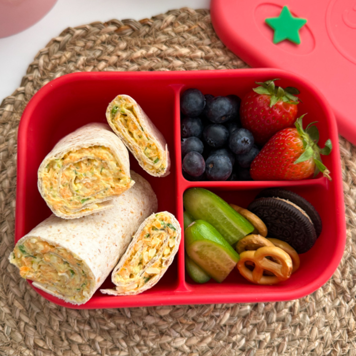 Veggie Cheese wraps served in a bright red child's lunchbox along with other lunchtime treats.