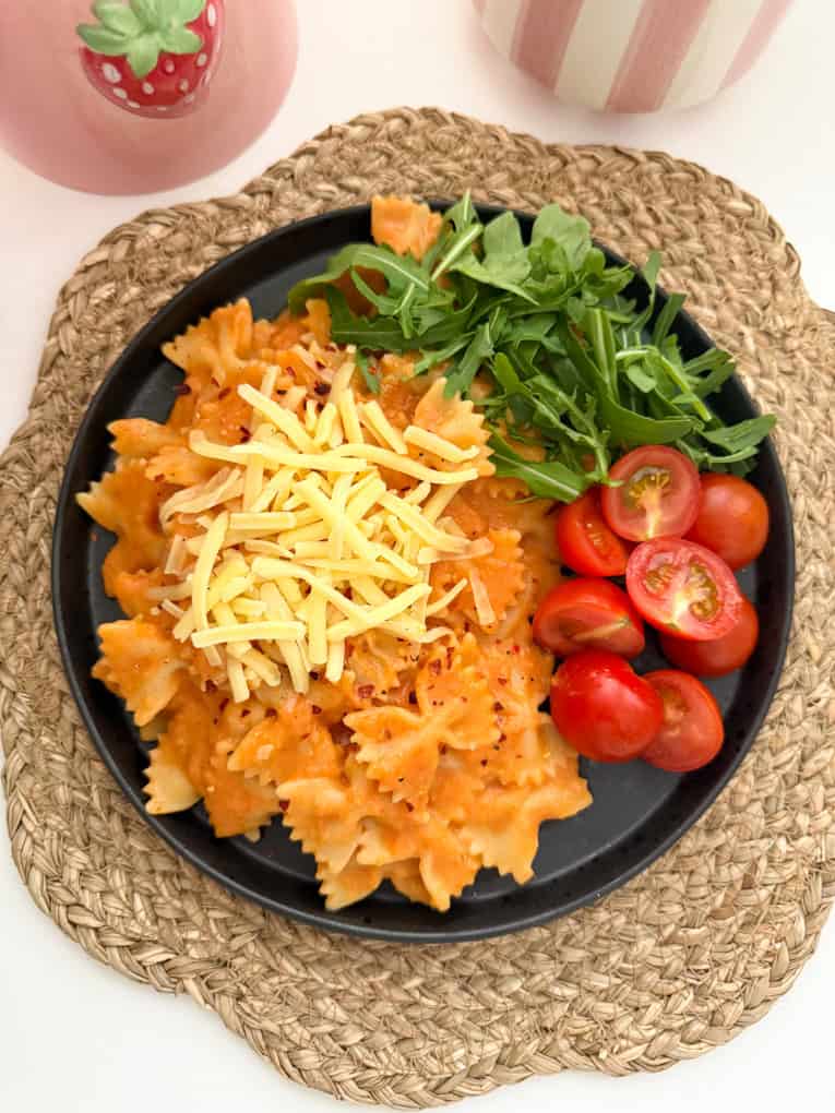 Butterbean sauce mixed into bow shaped pasta and served with chopped cherry tomato's and salad leaves, garnished with grated cheese.