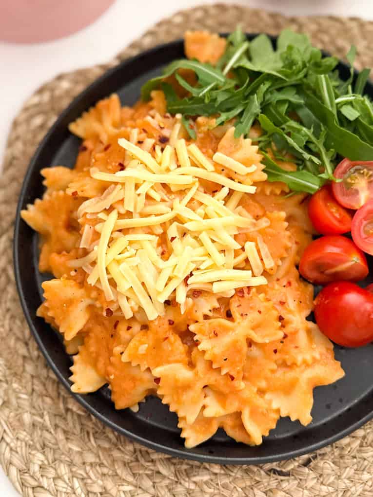 Butterbean sauce mixed into bow shaped pasta and served with chopped cherry tomato's and salad leaves, garnished with grated cheese.