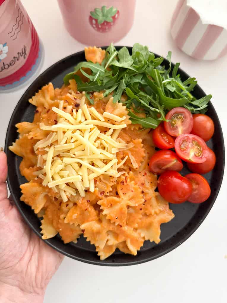 Butterbean sauce mixed into bow shaped pasta and served with chopped cherry tomato's and salad leaves, garnished with grated cheese.