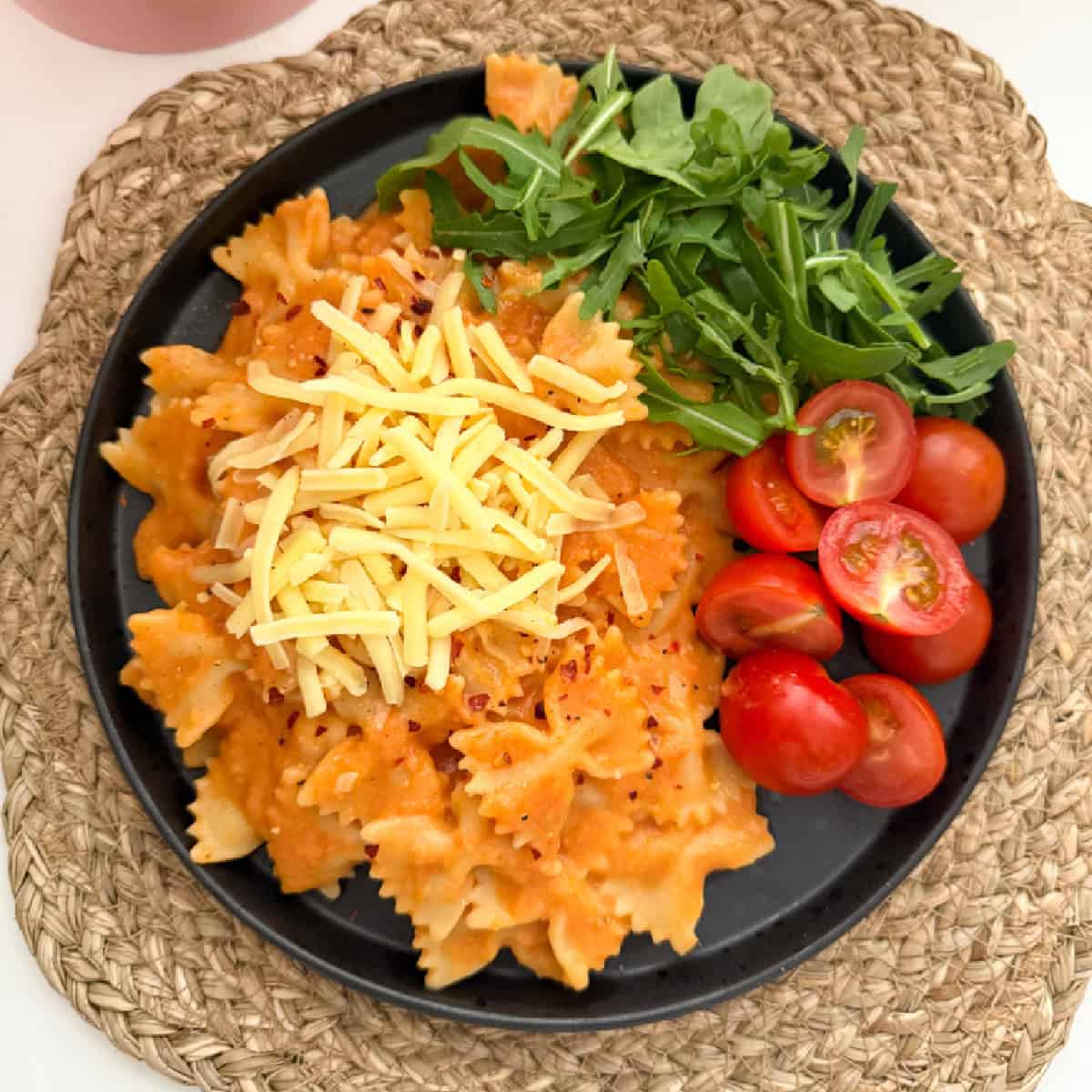 Butterbean sauce mixed into bow shaped pasta and served with chopped cherry tomato's and salad leaves, garnished with grated cheese.