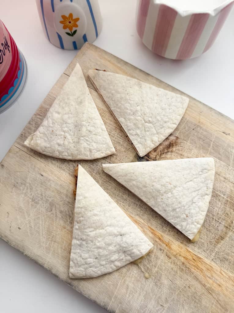 Chocolate banana wraps cut into triangle shaped pieces and arranged on a wooden chopping board.